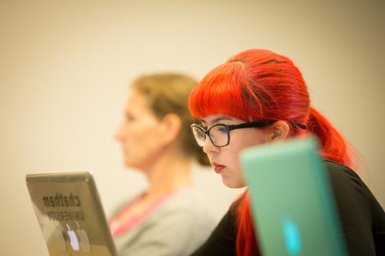 图为英国立博体育官网的一名女学生在讲课时在笔记本电脑上写字.
