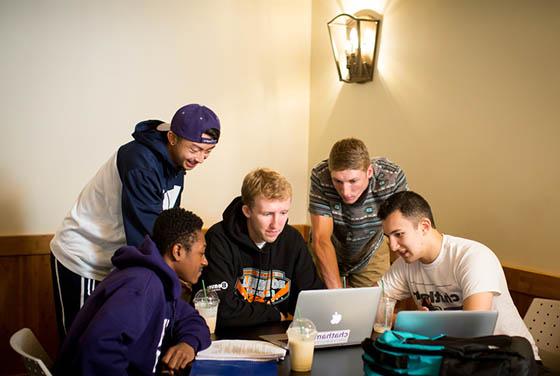 图为一群立博体育官网的男学生围着几台笔记本电脑一起工作