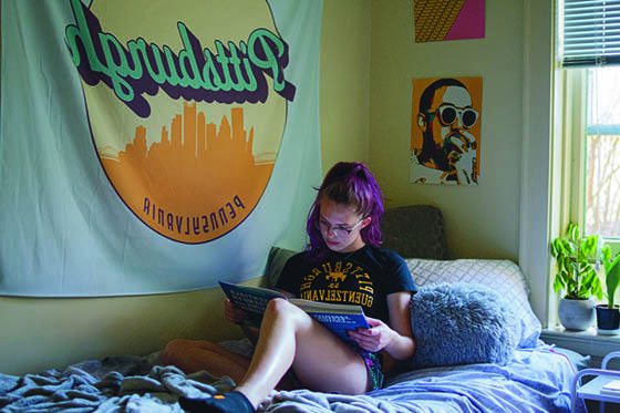 图为英国立博体育官网的一名女学生坐在宿舍的床上读书